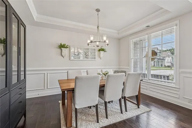 a dining room with furniture a chandelier and wooden floor