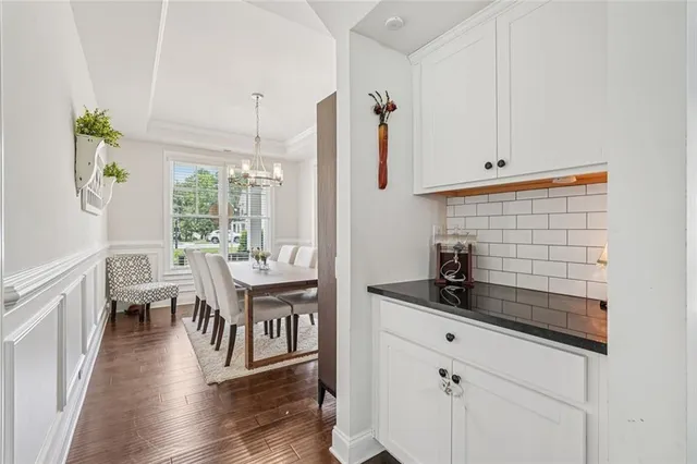 a kitchen with stainless steel appliances kitchen island granite countertop a sink a stove a dining table and chairs