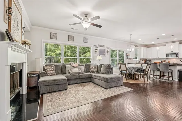 a living room with fireplace furniture and a large window