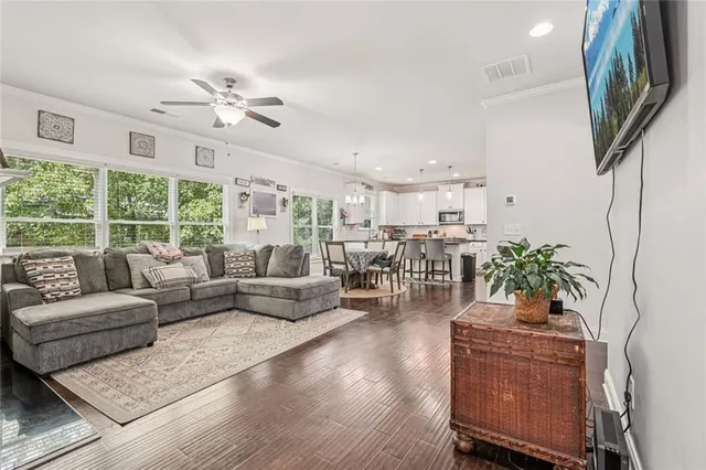 a living room with furniture a chandelier and a large window