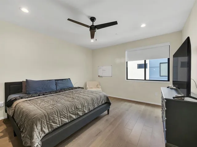 a bedroom with a large bed and a flat screen tv