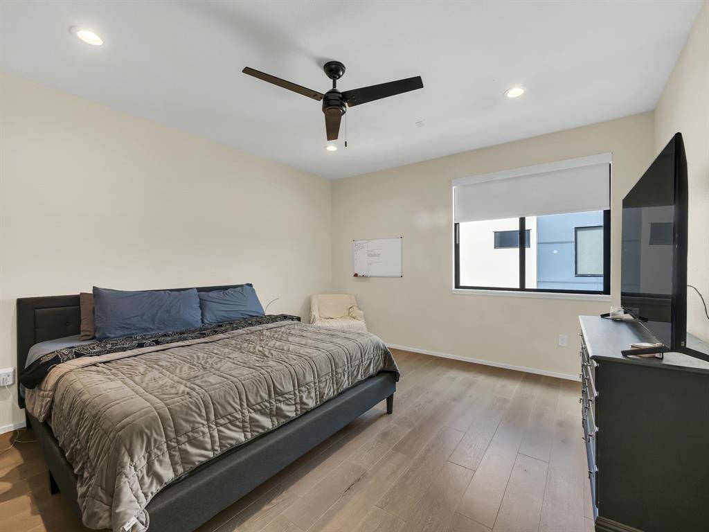 4703 Munger Avenue, Unit 101 Dallas, TX 75204 - Photo 13 of 26 a bedroom with a large bed and a flat screen tv