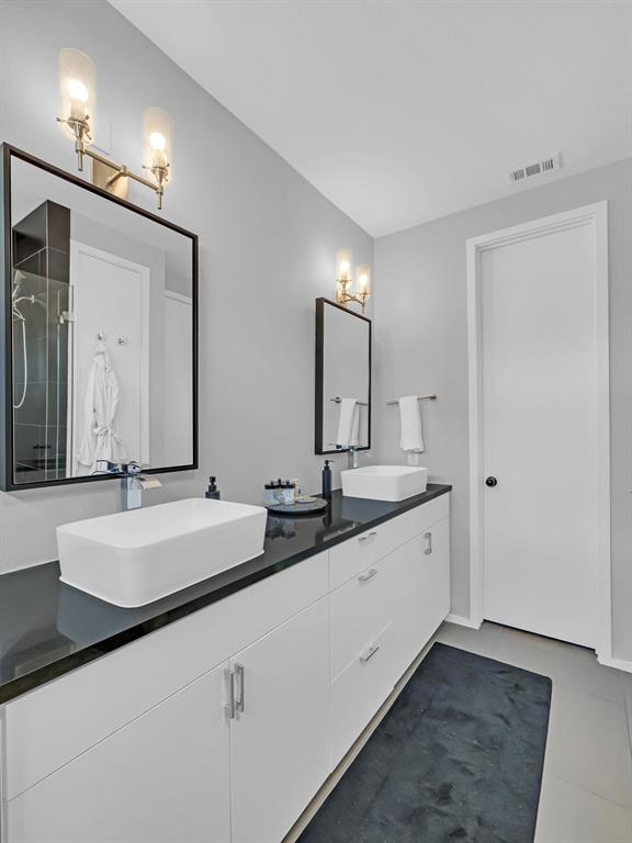 4703 Munger Avenue, Unit 101 Dallas, TX 75204 - Photo 15 of 26 a bathroom with a double vanity sink and a mirror