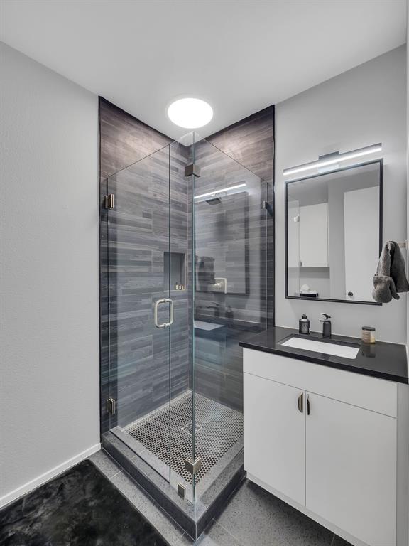 4703 Munger Avenue, Unit 101 Dallas, TX 75204 - Photo 8 of 26 a bathroom with a shower sink and mirror