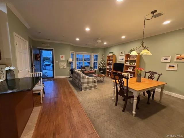 a living room with furniture kitchen view and a wooden floor