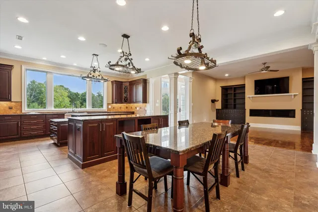 a large kitchen with kitchen island granite countertop a large counter top space and stainless steel appliances