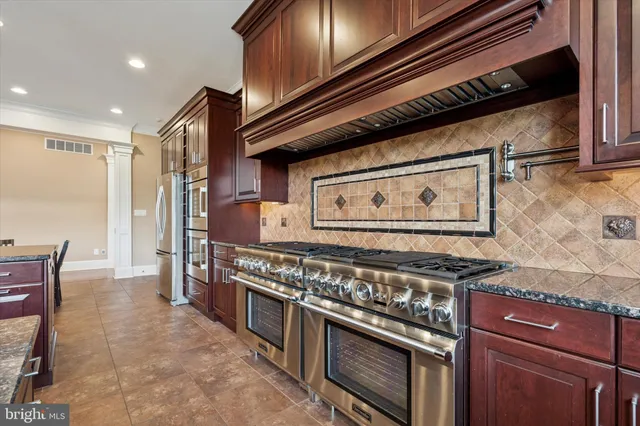 a kitchen with granite countertop stove and cabinets