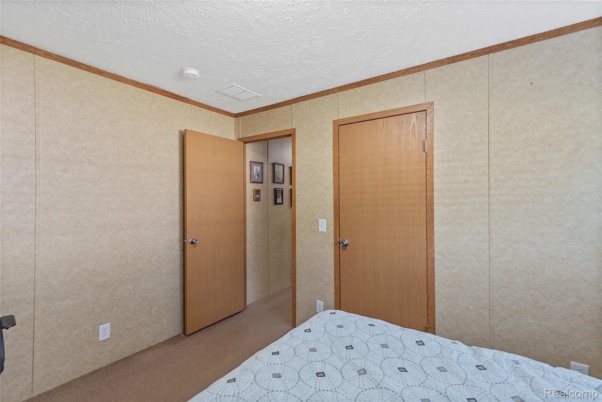 111 Riviera Oxford, MI 48371 - Photo 14 of 22 Carpeted bedroom with crown molding and a textured ceiling