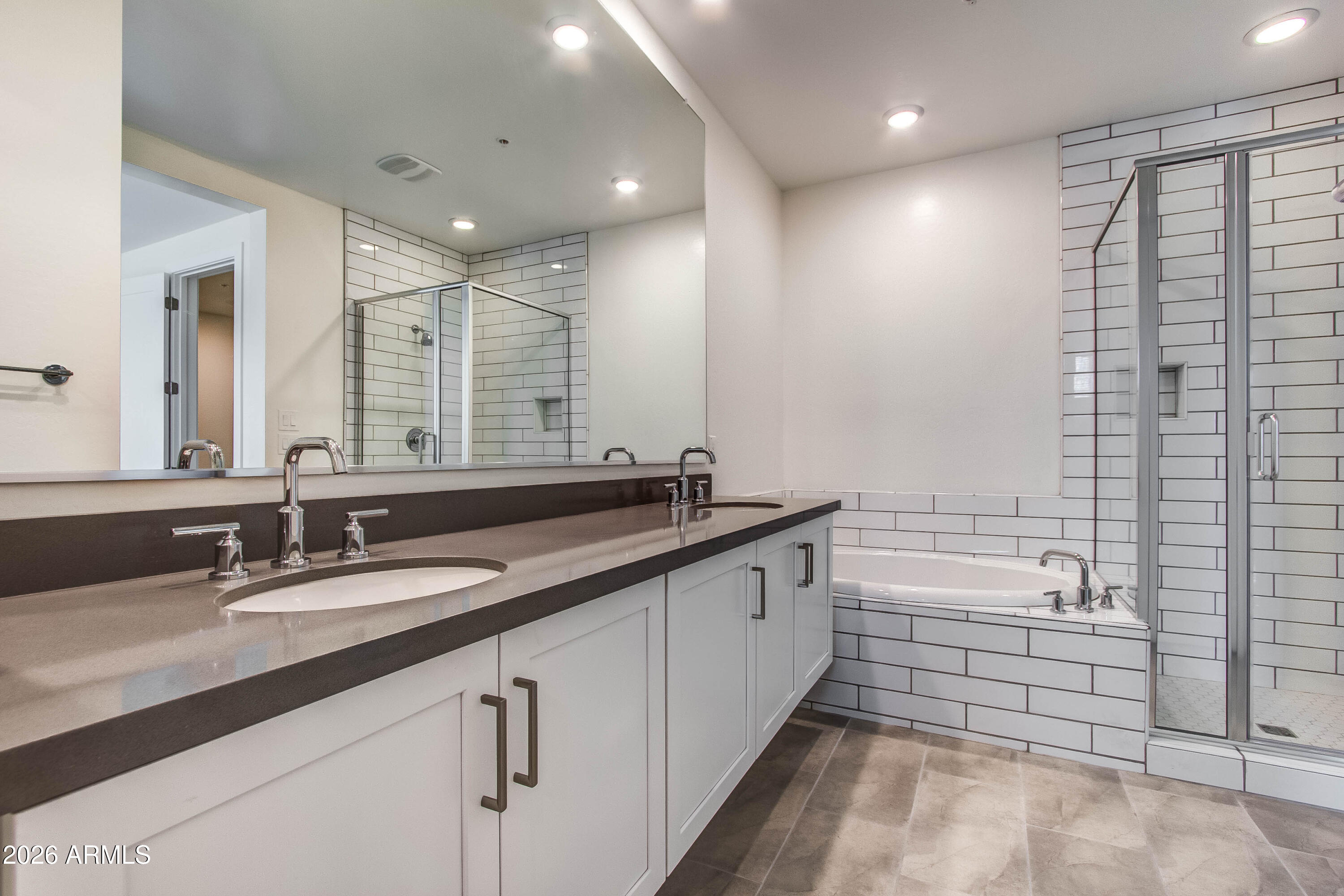 3855 South McQueen Road, Unit 50 Chandler, AZ 85286 - Photo 10 of 14 a bathroom with a double vanity sink and mirror with bathtub