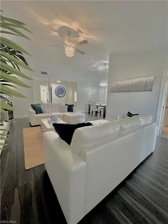 a living room with furniture and a large mirror on a dresser