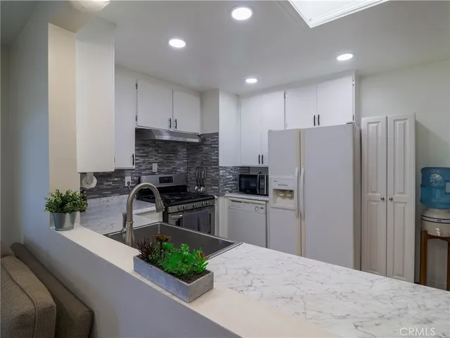 a kitchen with a refrigerator and a sink