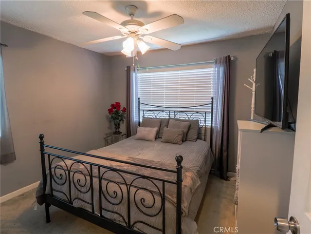 a bedroom with a bed a chandelier and a dresser