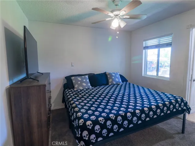 a bedroom with a bed and a flat tv screen on a dresser
