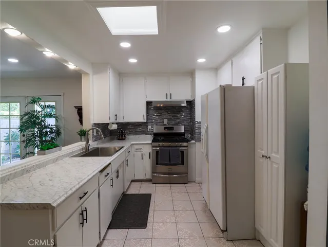 a kitchen with stainless steel appliances granite countertop a refrigerator and a sink
