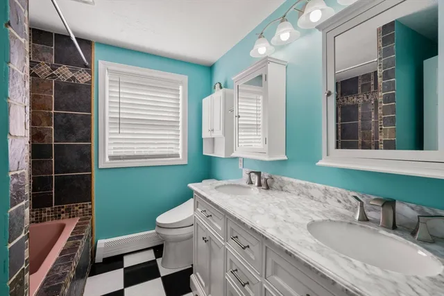 a bathroom with a granite countertop toilet sink and mirror