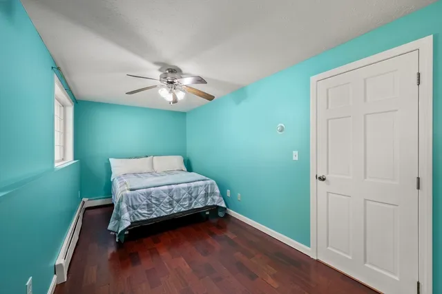 a bedroom with a bed and a chandelier fan