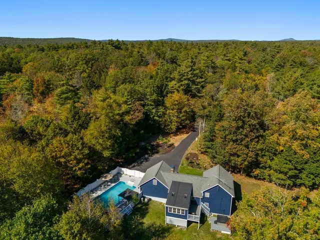 an aerial view of residential houses with outdoor space and trees