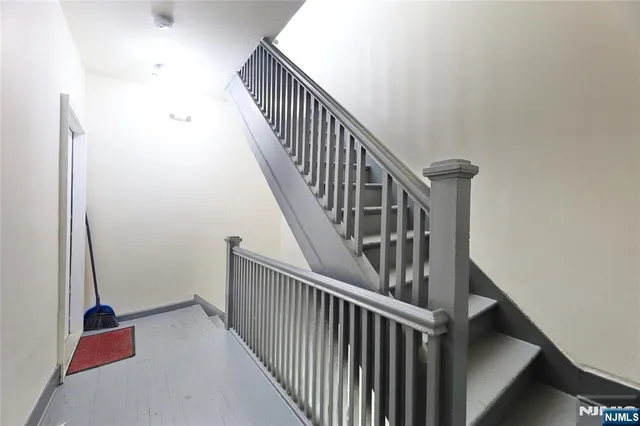 a view of staircase with railing and white walls