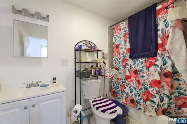 a bathroom with a sink toilet and shower curtain