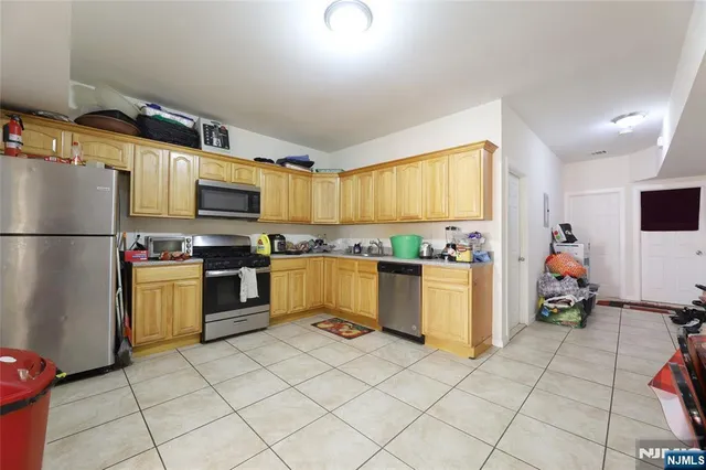 a kitchen with granite countertop a refrigerator and a stove top oven