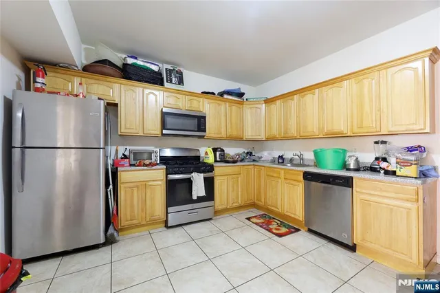 a kitchen with granite countertop a refrigerator and a stove top oven