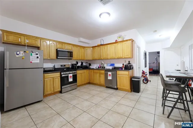 a kitchen with a sink a refrigerator and cabinets