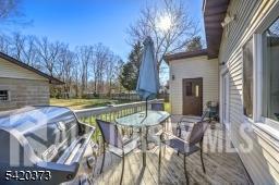 181 East Pleasant Grove Road Jackson, NJ 08527 - Photo 23 of 27 a view of a patio with table and chairs and floor to ceiling window with wooden fence
