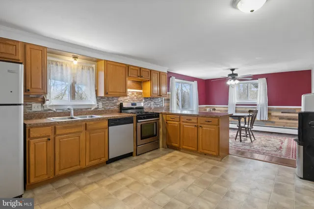 a kitchen with a stove a sink refrigerator and a microwave