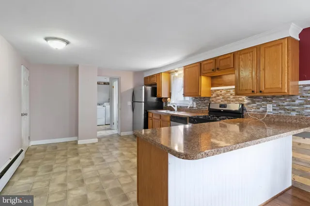 a large kitchen with kitchen island granite countertop a large window and a counter top space