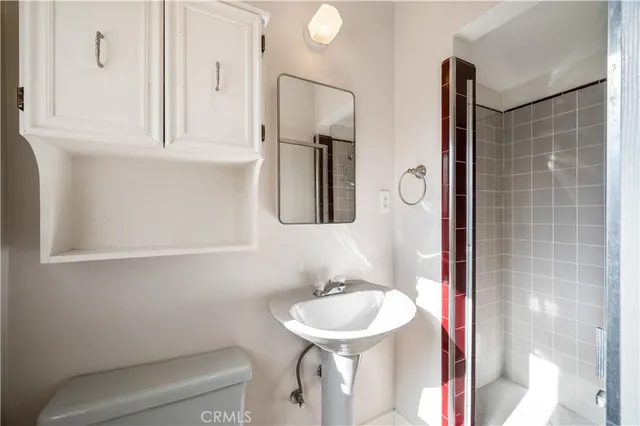 a bathroom with a sink a toilet and mirror