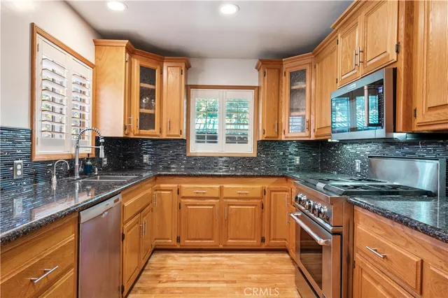 a kitchen with stainless steel appliances granite countertop sink stove and cabinets