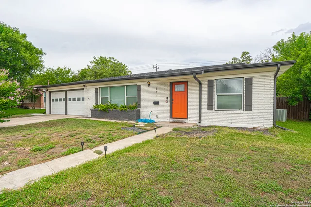 a view of a house with a backyard and a tree