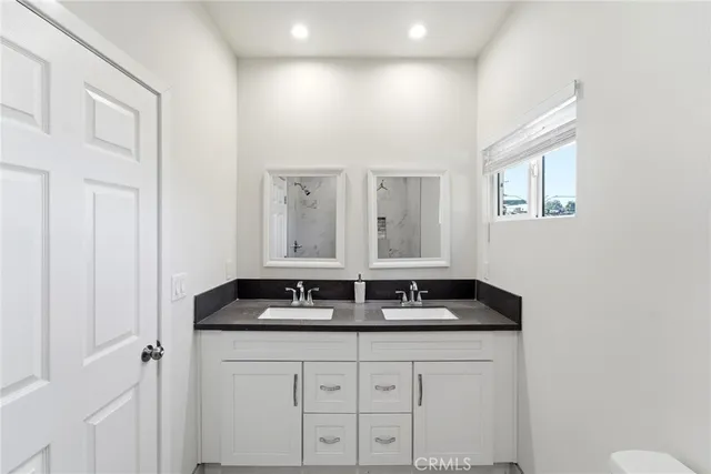 a bathroom with a granite countertop sink a mirror and a window