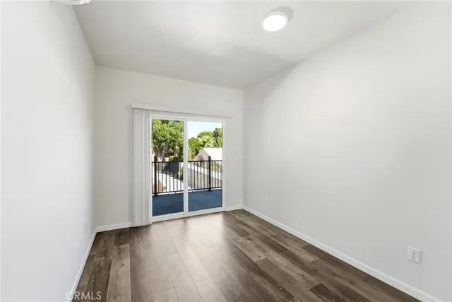 a view of a hallway with wooden floor and a window