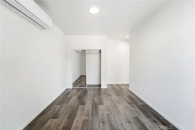 a view of a room with wooden floor and white walls