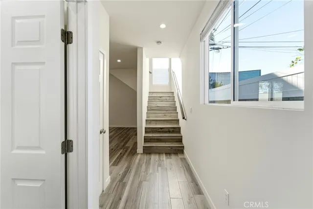 a view of a hallway with wooden floor and staircase