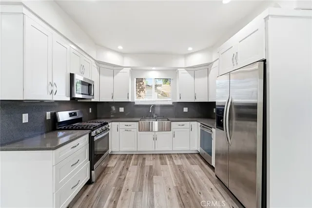 a kitchen with a refrigerator sink and cabinets