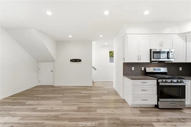 a kitchen with stainless steel appliances a stove top oven a sink and a refrigerator