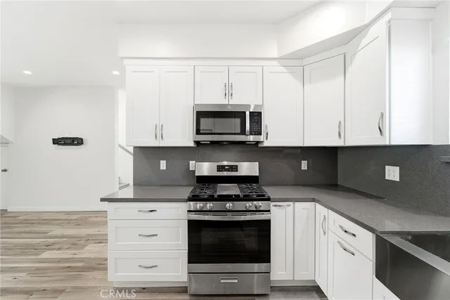 a kitchen with granite countertop a stove and a microwave