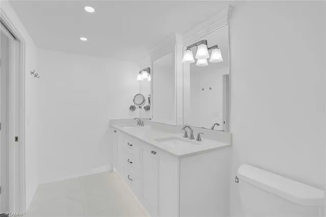 a bathroom with a sink mirror and toilet
