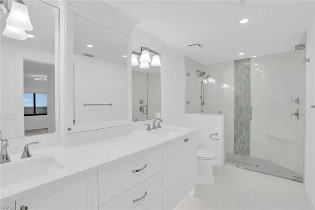a spacious bathroom with a double vanity sink mirror and shower