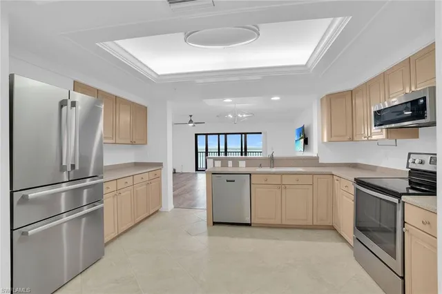 a kitchen with granite countertop stainless steel appliances a refrigerator stove top oven and sink