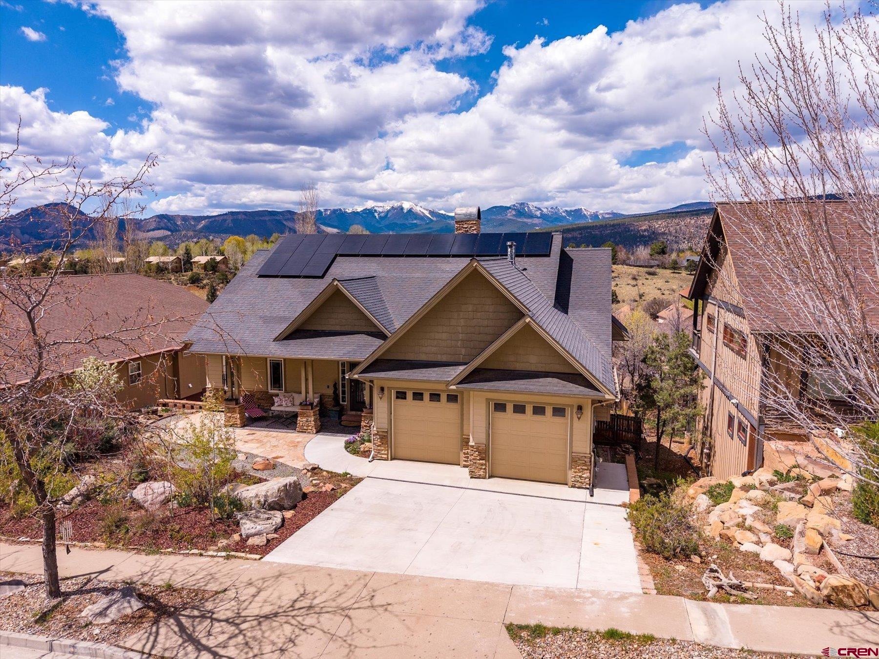 a view of a white house with a yard and wooden fence