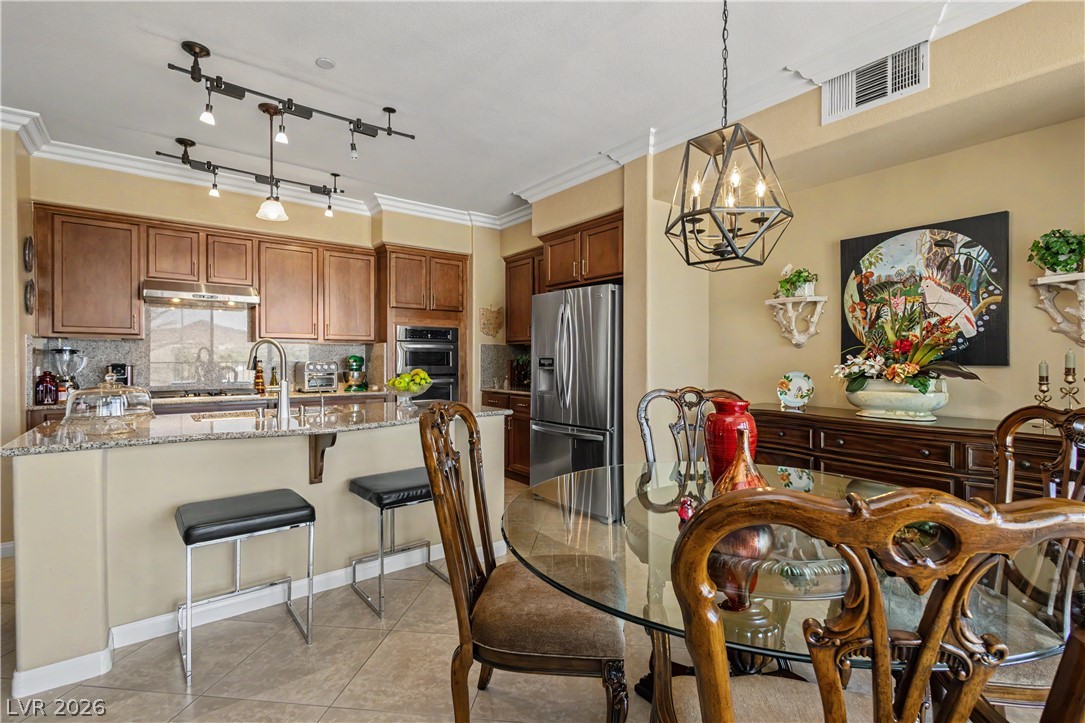 2555 Hampton Road, Unit 3308 Henderson, NV 89052 - Photo 16 of 65 Culinary adventures await in this kitchen, boasting abundant cabinetry, a granite breakfast bar, and contemporary lighting.