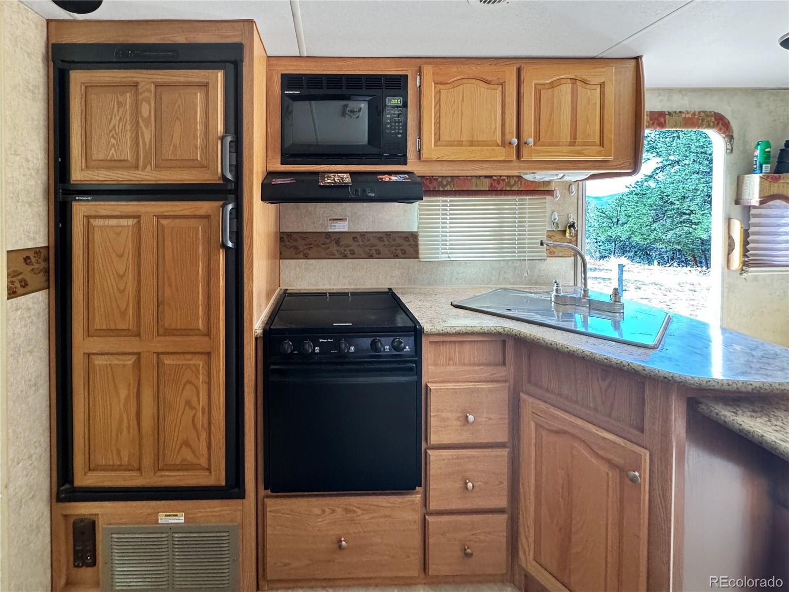 1525 L Path Cotopaxi, CO 81223 - Photo 13 of 28 a kitchen with granite countertop a refrigerator stove and microwave