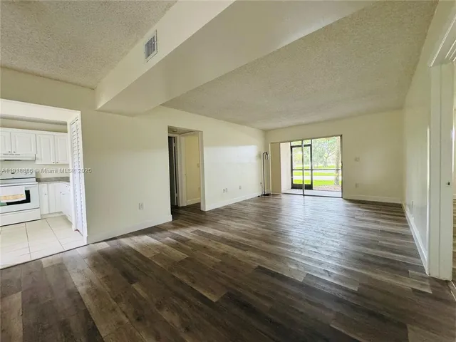 an empty room with wooden floor and a window