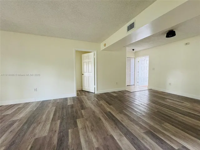 a view of an empty room and wooden floor