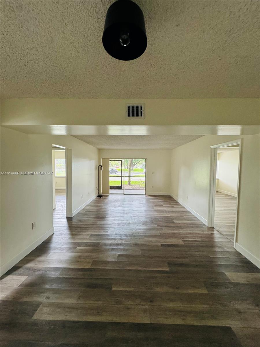 701 North Pine Island Road, Unit 101 Plantation, FL 33324 - Photo 4 of 31 a view of empty room with wooden floor and fan