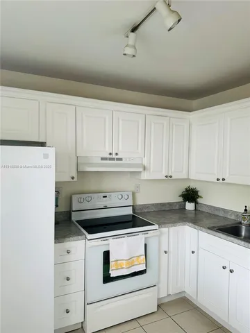 a kitchen with white cabinets and white appliances
