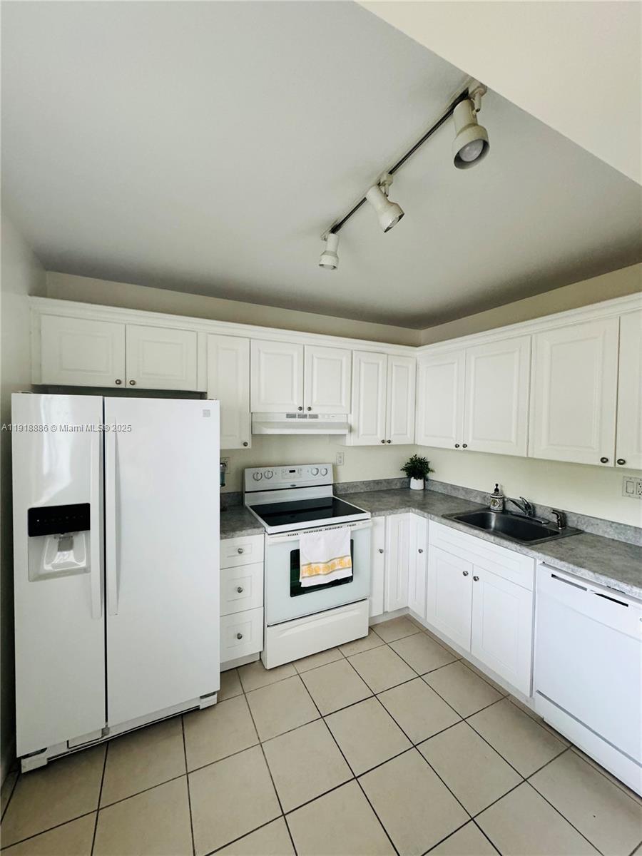701 North Pine Island Road, Unit 101 Plantation, FL 33324 - Photo 7 of 31 a kitchen with granite countertop cabinets and white appliances